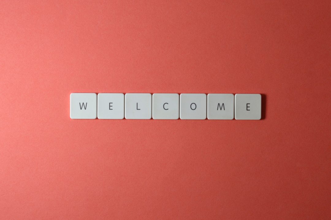 grey squares spelling out the word "Welcome" on a red background.