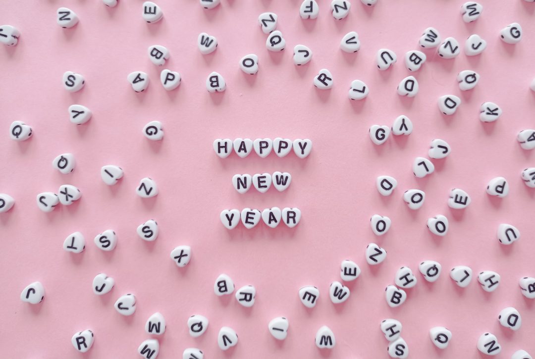 Happy New Year beads on a pink background.
